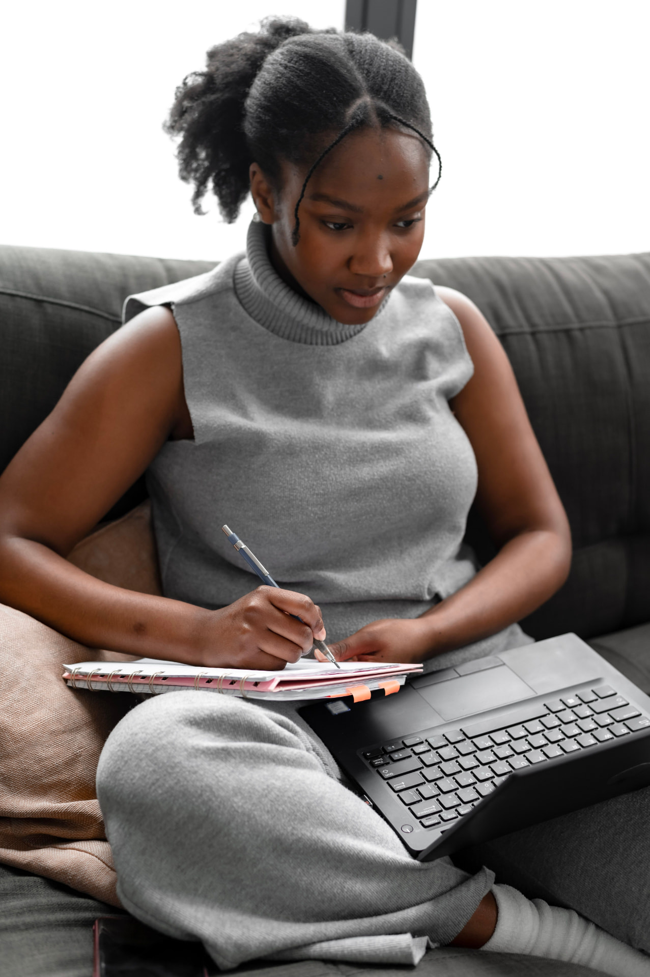 Personne travaillant depuis chez elle avec un ordinateur portable et un téléphone