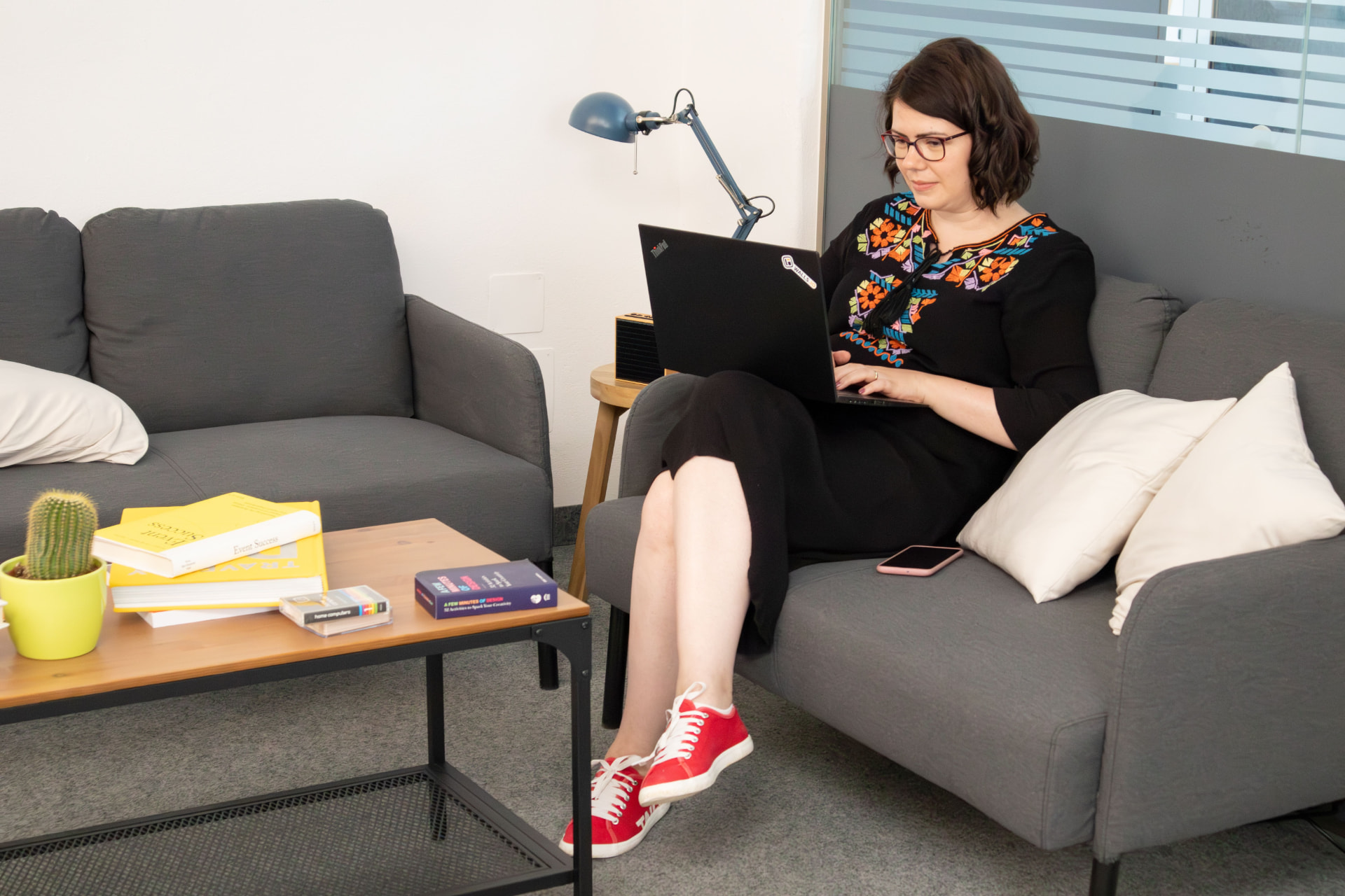 Personne travaillant depuis chez elle avec un ordinateur portable et un téléphone
